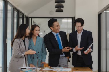 Bir grup işçi, patronlarının emrettiği gibi zamanında tamamlanan işleri tartışırken ofiste mutlu bir şekilde çalışırlar ve bir grup girişimci birlikte çalışırken eğlenirler..