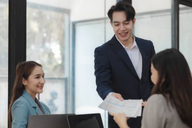 Bir grup işçi, patronlarının emrettiği gibi zamanında tamamlanan işleri tartışırken ofiste mutlu bir şekilde çalışırlar ve bir grup girişimci birlikte çalışırken eğlenirler..