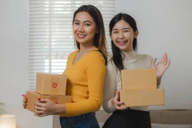 İki çevrimiçi satıcı ellerinde kutular dolusu ürün tutuyordu, iki operatör, ürünleri mağazadan satın alan müşterilere teslim etmek için paket hazırlıyordu..