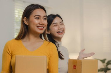 İki çevrimiçi satıcı ellerinde kutular dolusu ürün tutuyordu, iki operatör, ürünleri mağazadan satın alan müşterilere teslim etmek için paket hazırlıyordu..