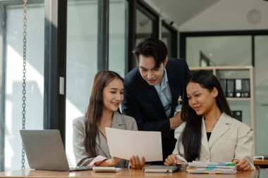 Bir grup iş adamı modern ofiste beyin fırtınası yapıyor, bir fikri paylaşmak için takım çalışması yapıyorlar, proje için kullanacakları strateji hakkında konuşuyorlar.
