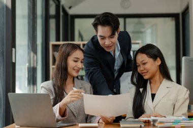 Bir grup iş adamı modern ofiste beyin fırtınası yapıyor, bir fikri paylaşmak için takım çalışması yapıyorlar, proje için kullanacakları strateji hakkında konuşuyorlar.