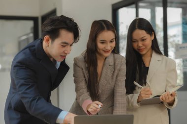 Bir grup iş adamı modern ofiste beyin fırtınası yapıyor, bir fikri paylaşmak için takım çalışması yapıyorlar, proje için kullanacakları strateji hakkında konuşuyorlar.
