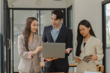 Bir grup iş adamı modern ofiste beyin fırtınası yapıyor, bir fikri paylaşmak için takım çalışması yapıyorlar, proje için kullanacakları strateji hakkında konuşuyorlar.