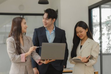 Bir grup iş adamı modern ofiste beyin fırtınası yapıyor, bir fikri paylaşmak için takım çalışması yapıyorlar, proje için kullanacakları strateji hakkında konuşuyorlar.