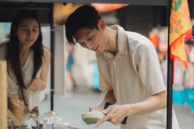 Genç ve sevimli çift güneşin altında geleneksel gıda pazarında dolaşıyorlar. Birbirlerini sevdikleri için konuştukları zaman yüzlerinden aşk beliriyor.