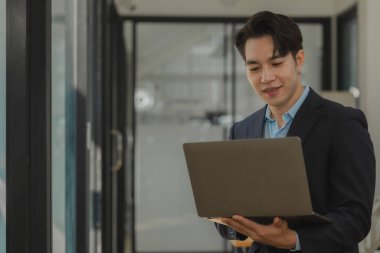 bir çalışan modern ofiste çalışıyor ve diğer iş arkadaşları aynı odada, ofiste çalışıyor, iş adamları, şirkette mutlu bir şekilde çalışıyorlar.