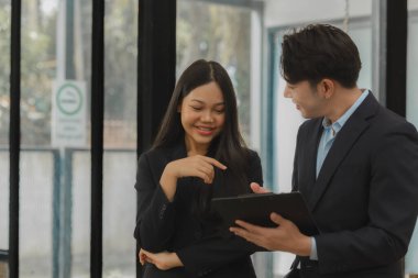 İki çalışan toplantı raporu hakkında konuşuyor. Meslektaşlar birbirleriyle tartışıyor ve tavsiyelerde bulunuyorlar. Mutlu çalışma ortamı, birlikte çalışma..