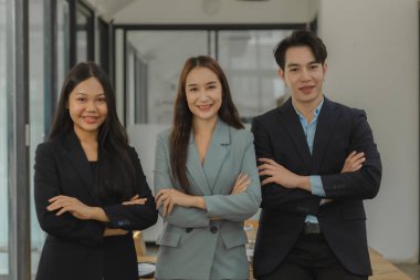 İş adamlarının resmi ofisteki kameraya bakıyor, bir girişimcinin gülümsemesi ve özgüvenle poz vermesi, yönetici kadrosunun portresi.