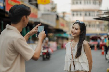 Güzel bir çift, ünlü seyahat yerlerinde fotoğraf çeker. Genç çift birlikte güzel görünür. Gezintiye çıkar ve gözlerinde sevgi ile gülümserler.