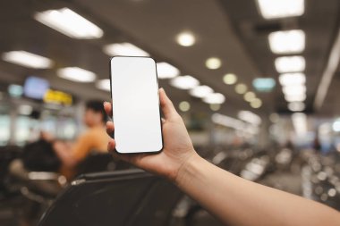 Uçağın ne zaman hazır olacağını kontrol etmek için akıllı telefonu kullanın. Havaalanında oturup internetten kontrol edin. Gezgin yurt dışına tatile gitmek için uçağa biner.