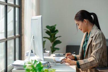bir iş kadını masasında çalışıyor, bir girişimci bilgisayarın önünde oturuyor ve yeni proje hakkında bilgi edinmek için çalışıyor, kadın çalışan ofiste