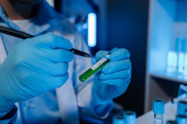 Bir bilim adamı deney için laboratuvar ekipmanı kullanır. Test tüpü kimyagerlerin deneylerde kullanması için gereklidir. Bilimsel araştırmacılar laboratuvar örneklerine yoğunlaşmalıdır.