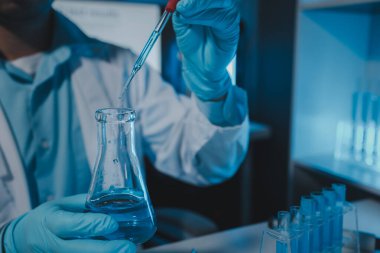 Bir bilim adamı deney için laboratuvar ekipmanı kullanır. Test tüpü kimyagerlerin deneylerde kullanması için gereklidir. Bilimsel araştırmacılar laboratuvar örneklerine yoğunlaşmalıdır.