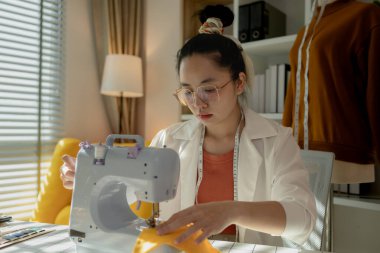 Göz kamaştırıcı yeni bir yüz tasarımcısı kumaş dikmek için küçük dikiş makinesini kullanıyor çünkü hayallerini gerçekleştirmek istiyor ki bu da kendi giyim şirketini kurmak.