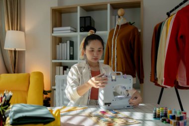 Göz kamaştırıcı yeni bir yüz tasarımcısı kumaş dikmek için küçük dikiş makinesini kullanıyor çünkü hayallerini gerçekleştirmek istiyor ki bu da kendi giyim şirketini kurmak.