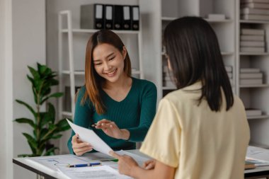 Girişimci ekibinden biri hedeflerine ulaşmak için önemli bir stratejiyi anlatıyor, ortaklar yeni proje hakkında rahat bir toplantı yapıyorlar, takım çalışması başarının anahtarıdır.