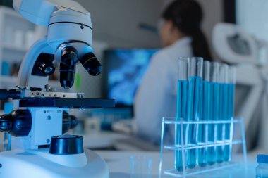 Bilimadamı laboratuvarda mikroskop kullanıyor, kimyasal araştırmacı kimya üzerine yoğunlaşarak çalışıyor, kimyager deneysel maddeleri test etmek için mikroskop kullanarak bir bilim deneyi yürütüyor.