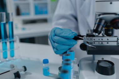 Bilimadamı laboratuvarda mikroskop kullanıyor, kimyasal araştırmacı kimya üzerine yoğunlaşarak çalışıyor, kimyager deneysel maddeleri test etmek için mikroskop kullanarak bir bilim deneyi yürütüyor.