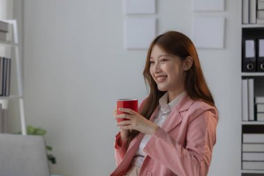 Bir iş kadını yüzünde gülümseme beliriyor çünkü ofiste dinlenirken kendini rahat ve rahat hissediyor. Güzel bir çalışan iş yerinde boş zamanlarının keyfini çıkarıyor.