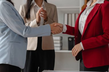 İki büyük şirket el sıkışır çünkü bir iş anlaşmasında anlaşırlar. İş adamları birleşmek için taahhüt sözleşmesi imzalarlar ve işlerini genişletirler çünkü normalde olduğundan daha fazla müşteri tabanına sahip olurlar.