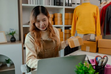 İşyeri sahibinin iş yerinde kontrol listesi var, müşterilere teslim edilmeden önce tüm paketler hakkında iyi hazırlıklar yapıyor, müşteri bilgilerini doğruluğu için kontrol ediyor.