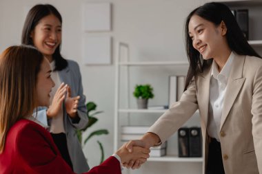 İki büyük şirket el sıkışır çünkü bir iş anlaşmasında anlaşırlar. İş adamları birleşmek için taahhüt sözleşmesi imzalarlar ve işlerini genişletirler çünkü normalde olduğundan daha fazla müşteri tabanına sahip olurlar.