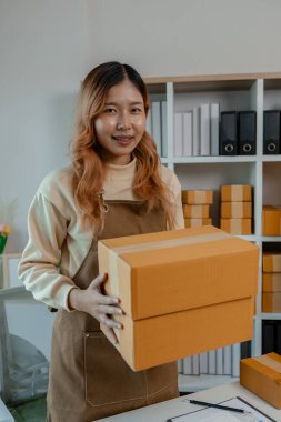 Güzel bir bayan girişimci iş yerindeyken kameraya bakar, bir iş yeri sahibi olduğu bir depodadır, çevrimiçi ürün satan küçük bir işletme için paketlerle dolu bir ofis.