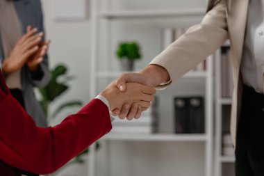 İki büyük şirket el sıkışır çünkü bir iş anlaşmasında anlaşırlar. İş adamları birleşmek için taahhüt sözleşmesi imzalarlar ve işlerini genişletirler çünkü normalde olduğundan daha fazla müşteri tabanına sahip olurlar.