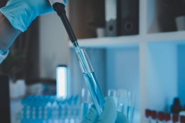Bir araştırmacı sıvı madde üzerinde bilimsel deneyler yapıyor, bir bilim adamı sıvı örneğini analiz etmek için laboratuvar ekipmanları kullanıyor, kimyasallar laboratuarda test ediliyor.