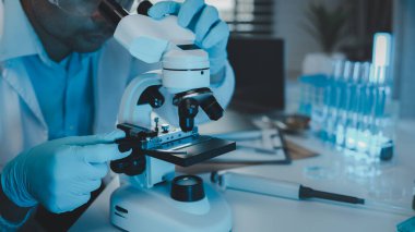Bir bilim adamı test örneğinde mikroskop kullanarak mikroskop kullanır. Bir araştırmacı yabancı cisimlere yakından bakmak için mikroskop kullanır. Laboratuvarda mikroskop kullanılıyor.