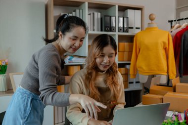 Bir girişimci, çalışanlarının giysi ürünlerini mağazadan müşterilere teslim etmek için hazır hale getirmek için çalıştıkları mağazadaki malları incelemeye geldi.