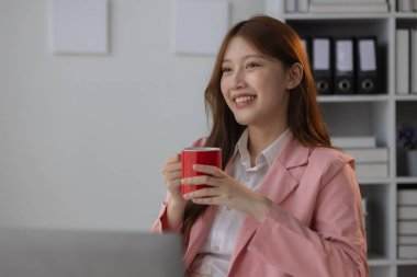 Bir iş kadını yüzünde gülümseme beliriyor çünkü ofiste dinlenirken kendini rahat ve rahat hissediyor. Güzel bir çalışan iş yerinde boş zamanlarının keyfini çıkarıyor.