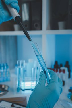 Bir araştırmacı sıvı madde üzerinde bilimsel deneyler yapıyor, bir bilim adamı sıvı örneğini analiz etmek için laboratuvar ekipmanları kullanıyor, kimyasallar laboratuarda test ediliyor.