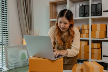 İşyeri sahibinin iş yerinde kontrol listesi var, müşterilere teslim edilmeden önce tüm paketler hakkında iyi hazırlıklar yapıyor, müşteri bilgilerini doğruluğu için kontrol ediyor.