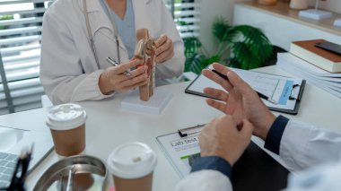 İki ENT uzmanı bir hasta için en uygun tedaviyi tartışıyorlar, iki doktor ENT tedavisi, anatomi, stetoskop, model hakkındaki görüşlerini paylaşıyorlar