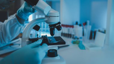 Bir bilim adamı test örneğinde mikroskop kullanarak mikroskop kullanır. Bir araştırmacı yabancı cisimlere yakından bakmak için mikroskop kullanır. Laboratuvarda mikroskop kullanılıyor.