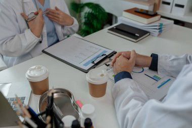 İki doktor hastanede özel bir ofiste oturup birbirleriyle bilgi alışverişinde bulundular. Doktorlar bunun en uygun tedavi yöntemi olduğunu tartıştılar. Stetoskop, uzman.