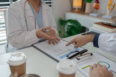 İki doktor hastanede özel bir ofiste oturup birbirleriyle bilgi alışverişinde bulundular. Doktorlar bunun en uygun tedavi yöntemi olduğunu tartıştılar. Stetoskop, uzman.