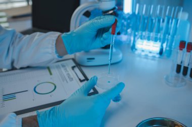 Bir araştırmacı sıvı madde üzerinde bilimsel deneyler yapıyor, bir bilim adamı sıvı örneğini analiz etmek için laboratuvar ekipmanları kullanıyor, kimyasallar laboratuarda test ediliyor.