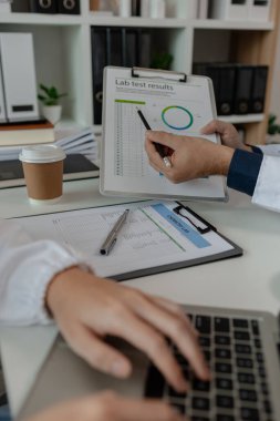 İki doktor hastanede özel bir ofiste oturup birbirleriyle bilgi alışverişinde bulundular. Doktorlar bunun en uygun tedavi yöntemi olduğunu tartıştılar. Stetoskop, uzman.