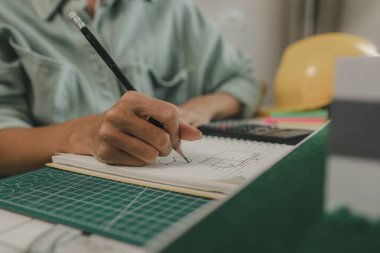 Mühendis ve yatırımcı, yakında inşa edilecek bir konut projesinin detaylarını görüşüyorlar. Bir mimar, müşterinin ihtiyaçlarını karşılayacak bir ev yapısı tasarlamak için bir mühendise danışıyor.