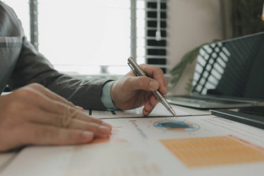 Bir işadamı özel ofisinde ve bir sürü evrak işiyle uğraşıyor. Pazarlama şirketinin üst düzey yöneticilerinden biri bu yılın gelir raporlarını inceliyor.