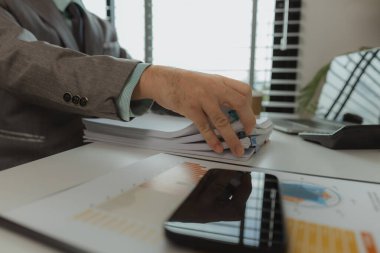 Bir ofis çalışanı her şeyi güvende tutmak için önemli belgeleri bir araya getiriyor. Bir iş adamı önemli iş belgelerini düzgün bir yere koyuyor. Belgeler ve raporlar.