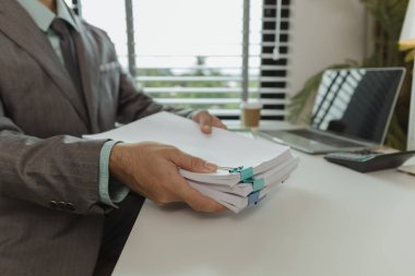 Bir ofis çalışanı her şeyi güvende tutmak için önemli belgeleri bir araya getiriyor. Bir iş adamı önemli iş belgelerini düzgün bir yere koyuyor. Belgeler ve raporlar.