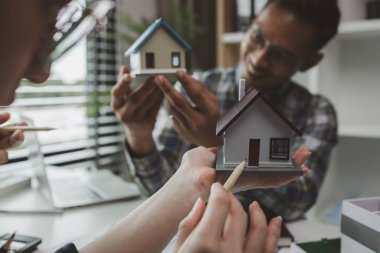 Mühendislerden oluşan bir ekip, tasarım yapısını analiz etmek ve müşterinin isteklerini karşılamak için ofiste toplanıyor. Mimarlar ve müteahhitlerden oluşan bir ekip, bir model eve dayanan tasarımı tartışmak için toplanıyor..