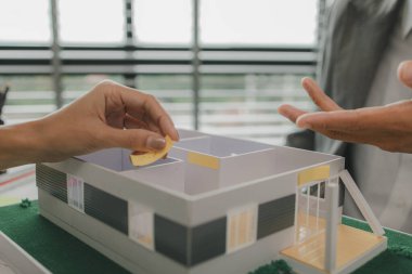 Bir ustabaşı ev yapısı hakkında bir mühendise danışıyor, n mimarı ve asistanı planlar, toplantı, proje, tartışma, takım çalışması hakkında beyin fırtınası yapıyor ve inceliyor.