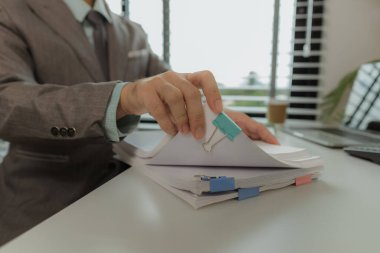 Bir ofis çalışanı her şeyi güvende tutmak için önemli belgeleri bir araya getiriyor. Bir iş adamı önemli iş belgelerini düzgün bir yere koyuyor. Belgeler ve raporlar.