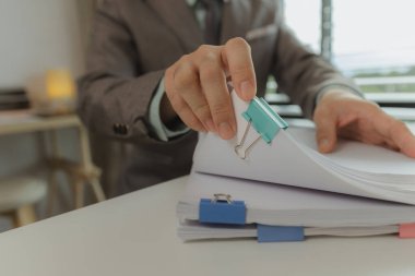 Bir ofis çalışanı her şeyi güvende tutmak için önemli belgeleri bir araya getiriyor. Bir iş adamı önemli iş belgelerini düzgün bir yere koyuyor. Belgeler ve raporlar.