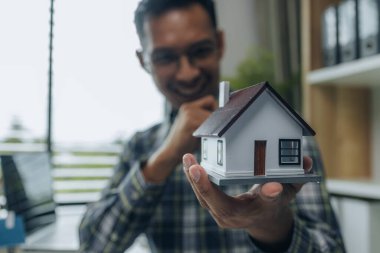 Mühendislerden oluşan bir ekip, tasarım yapısını analiz etmek ve müşterinin isteklerini karşılamak için ofiste toplanıyor. Mimarlar ve müteahhitlerden oluşan bir ekip, bir model eve dayanan tasarımı tartışmak için toplanıyor..